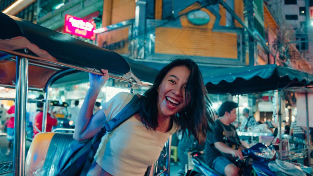 Youn person smiling getting out of a tuk tuk
